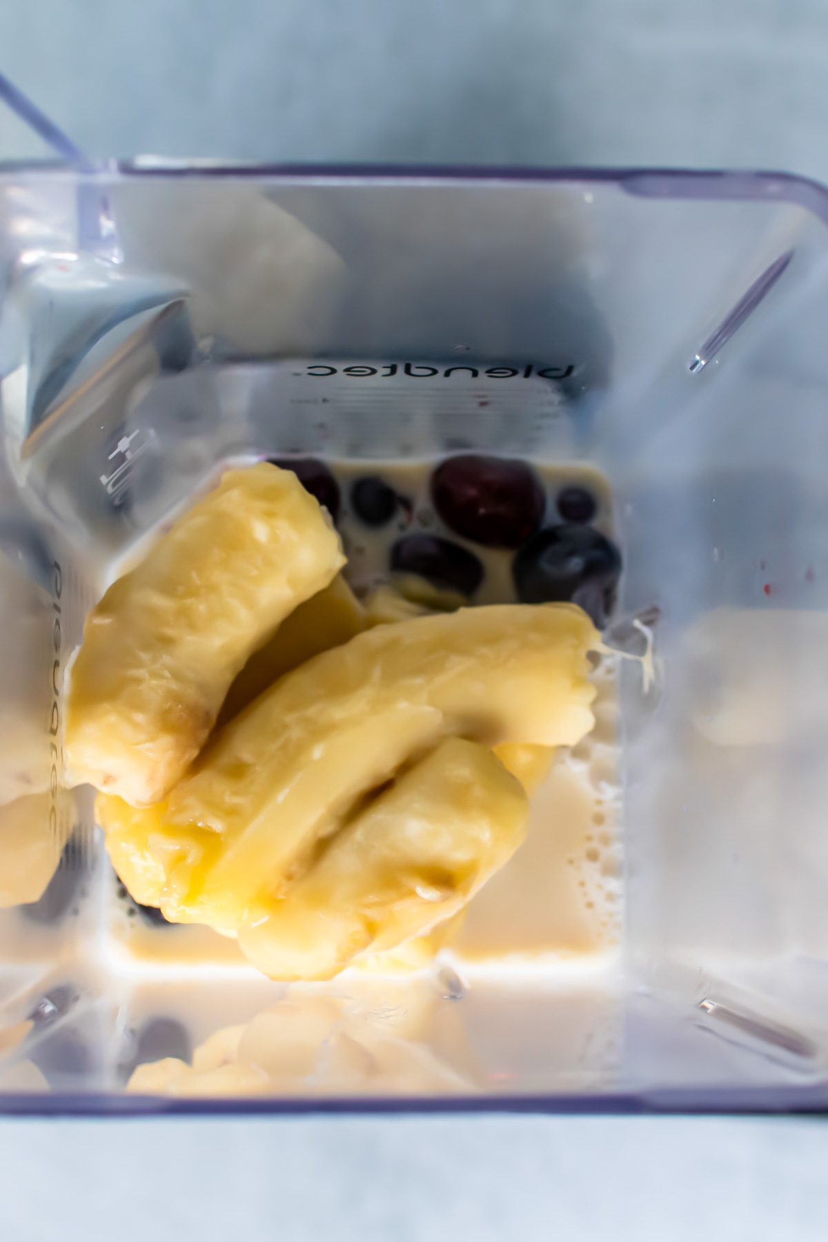 Photo of the ingredients for a cherry smoothie added to the blender jug.