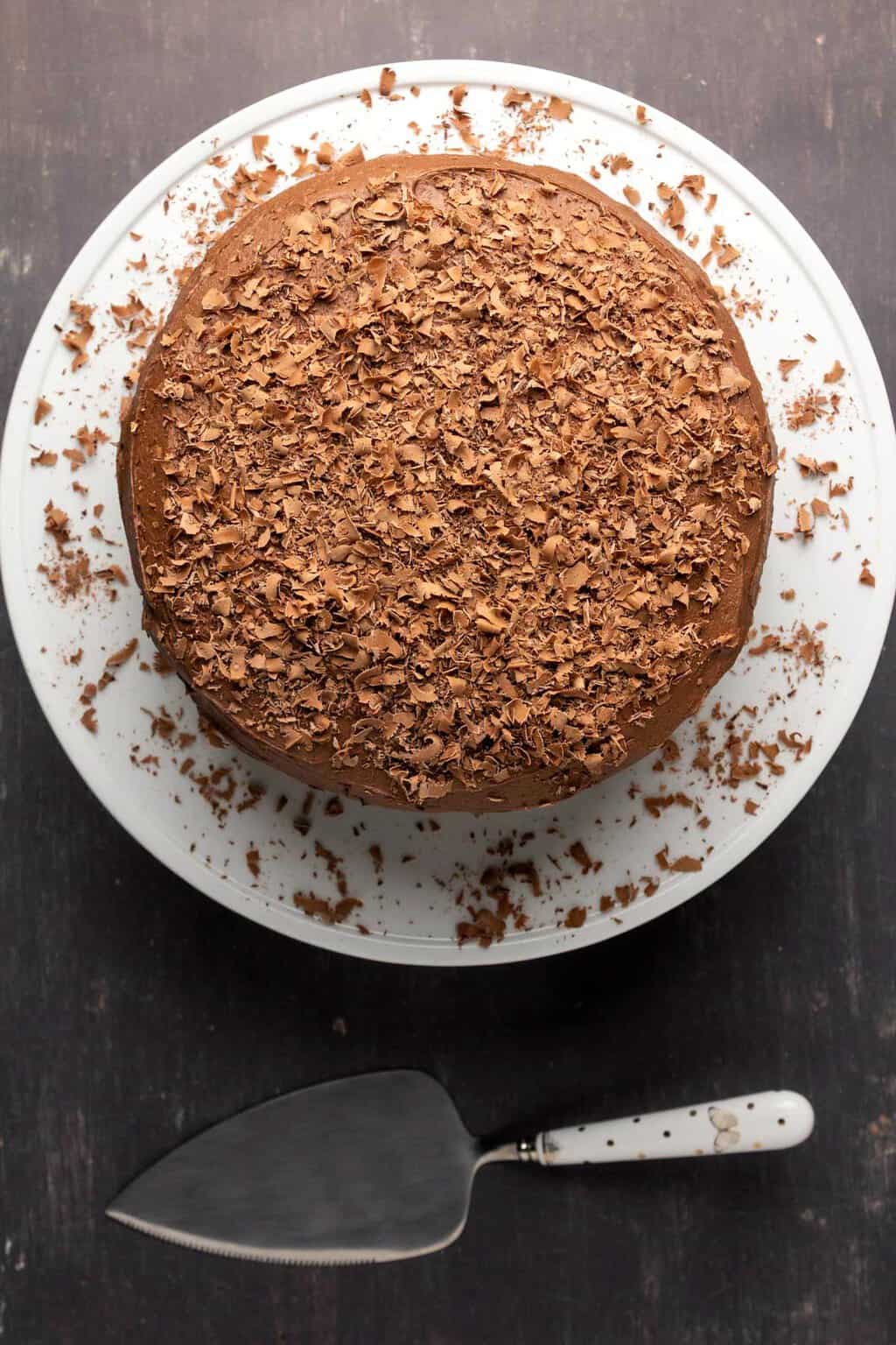 Chocolate cake on a white cake stand. 