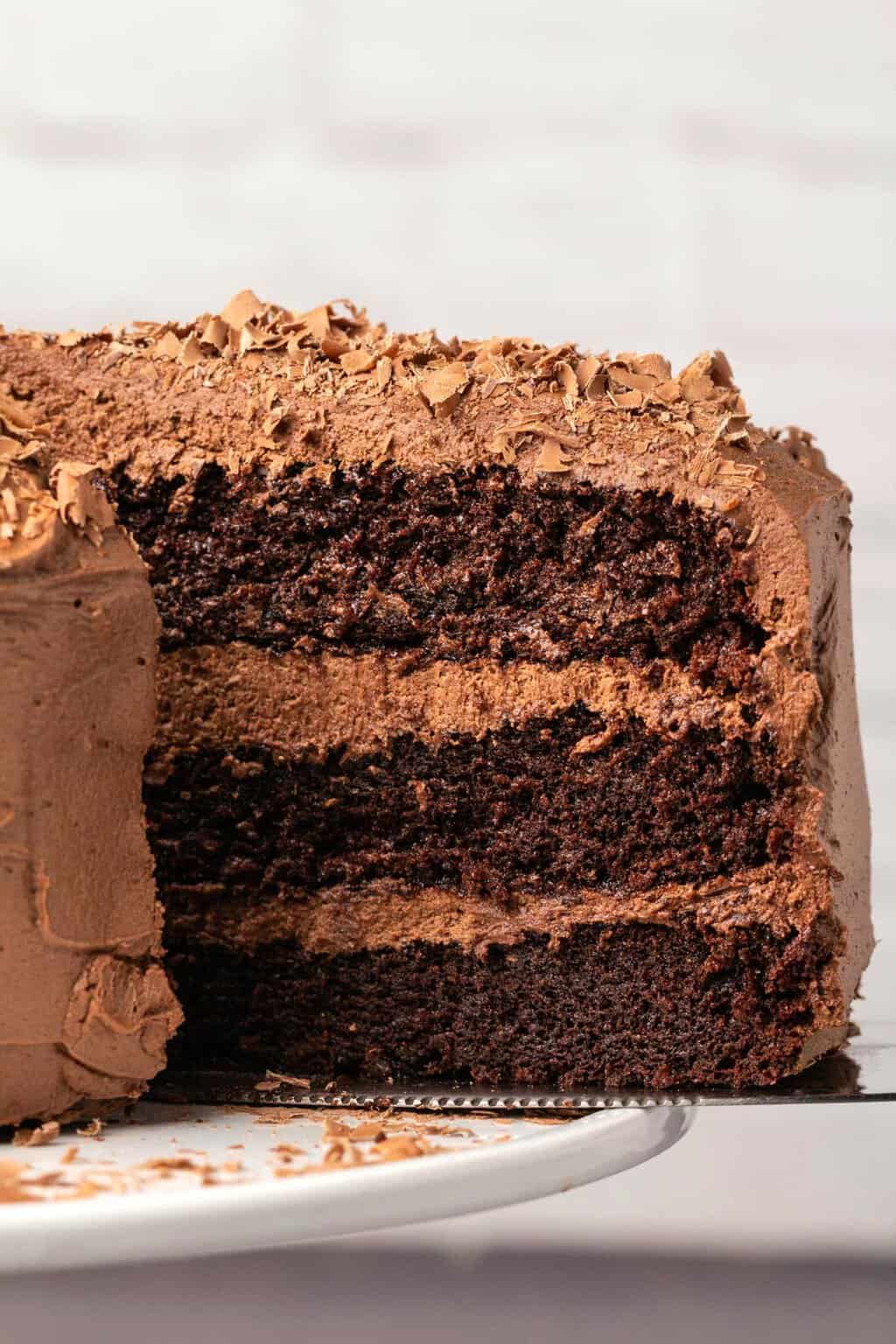 Slice of dairy free chocolate cake on a cake lifter. 