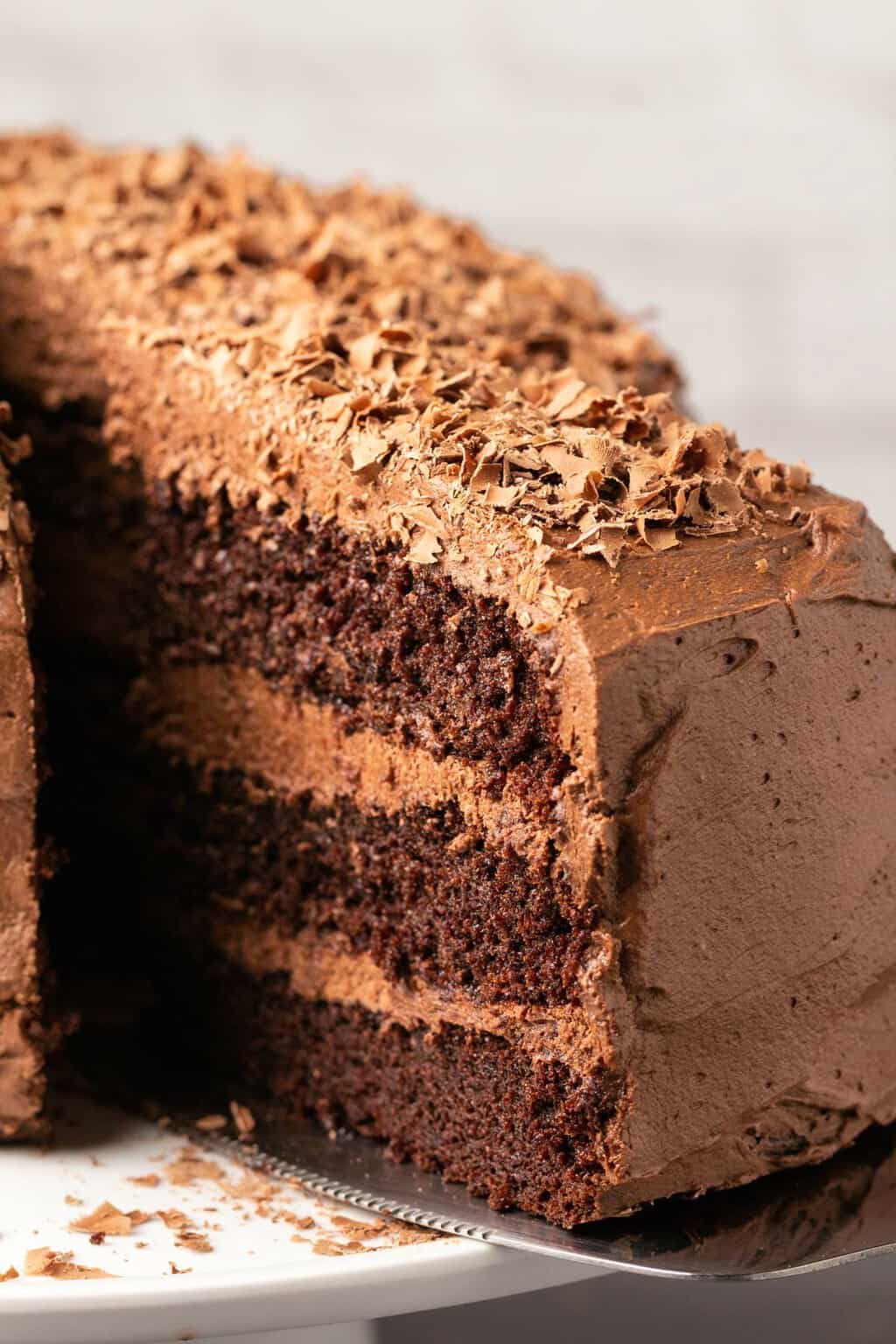 Dairy free chocolate cake on a white cake stand. 