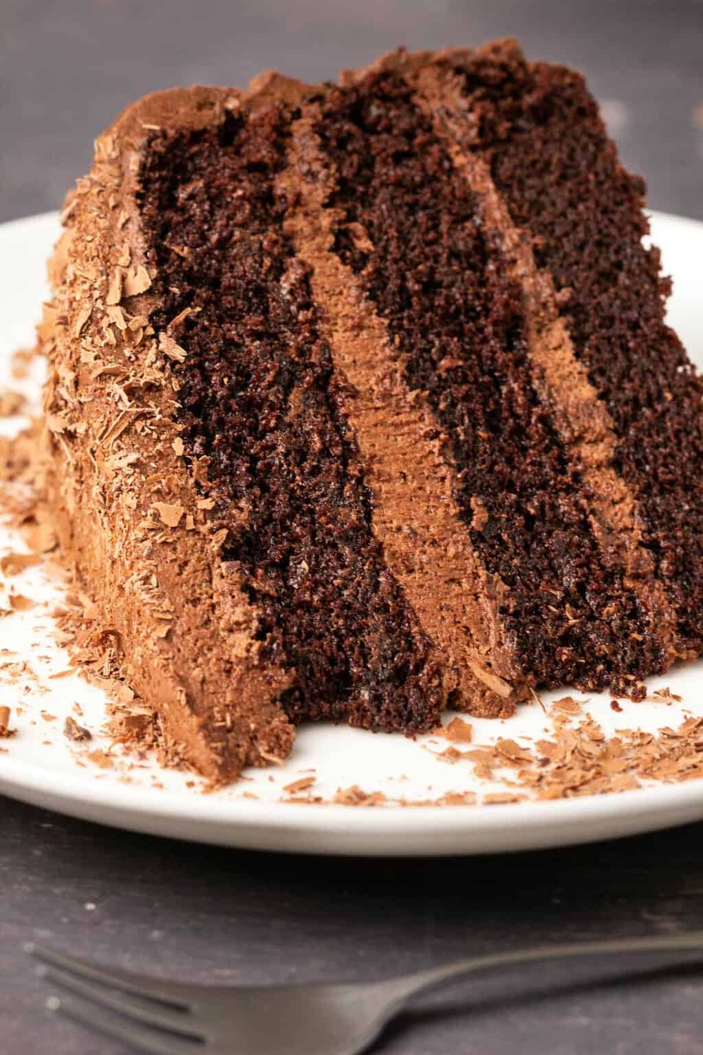 Slice of dairy free chocolate cake on a white plate. 