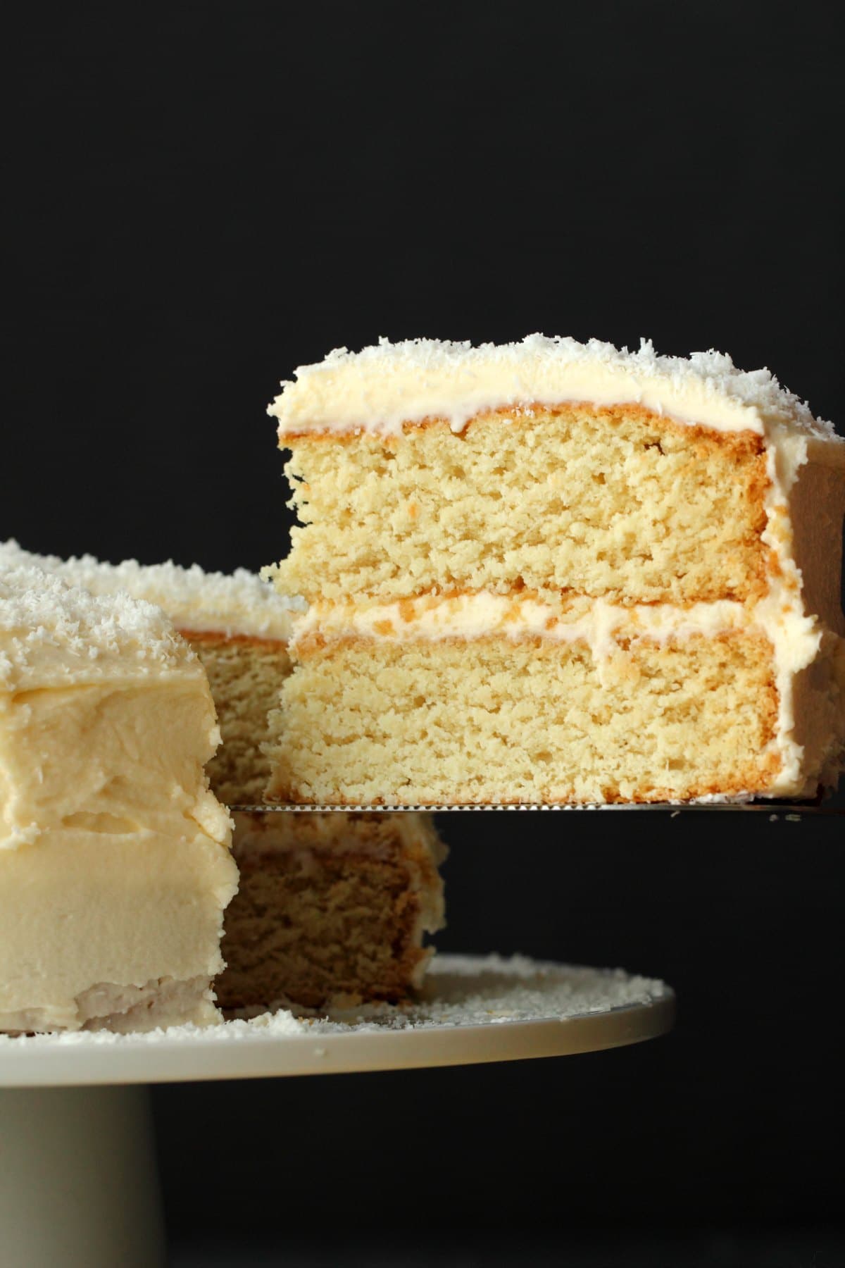 Slice of vegan coconut cake on a cake lifter. 