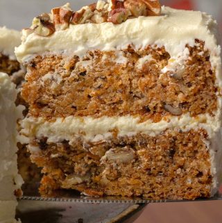 Sliced vegan gluten free carrot cake on a cake stand.