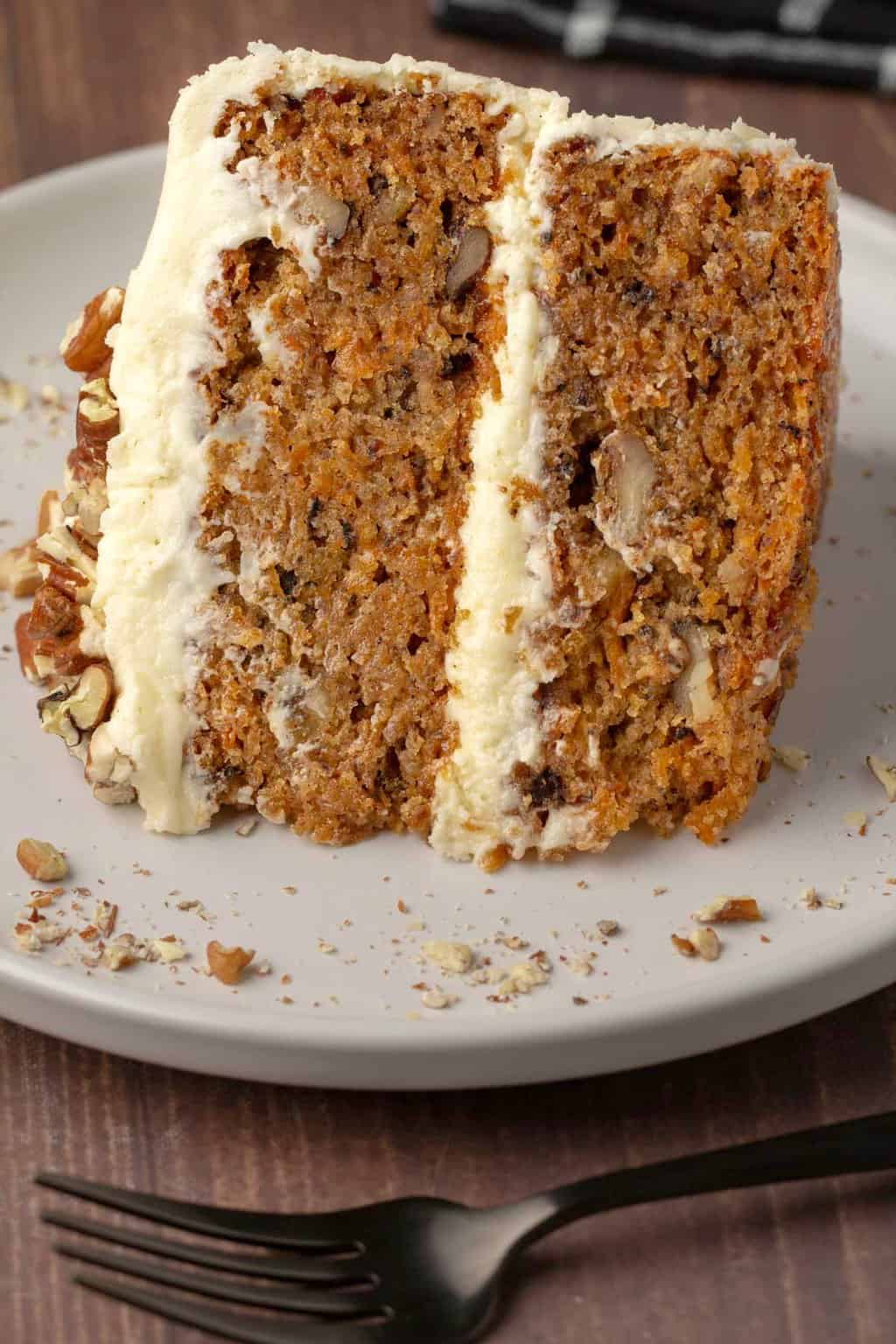 Slice of vegan gluten free carrot cake on a white plate. 