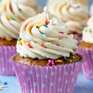 Vegan gluten free vanilla cupcakes topped with frosting and sprinkles.