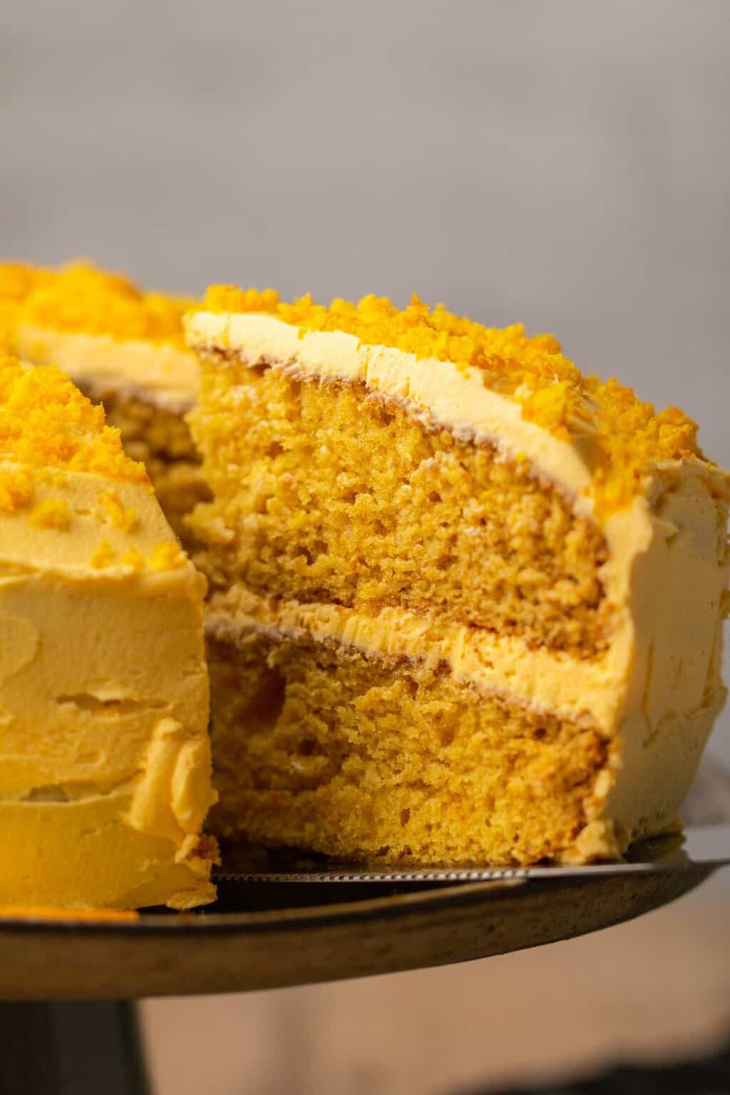 Sliced vegan orange cake with a cake lifter. 