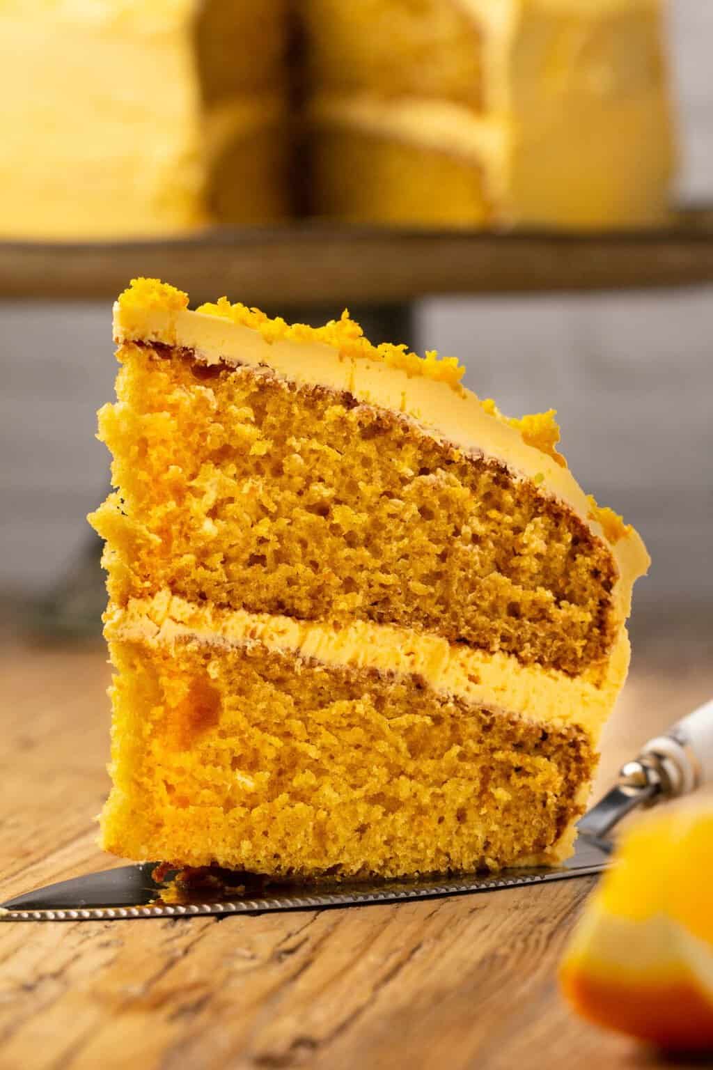 Slice of vegan orange cake on a cake lifter. 