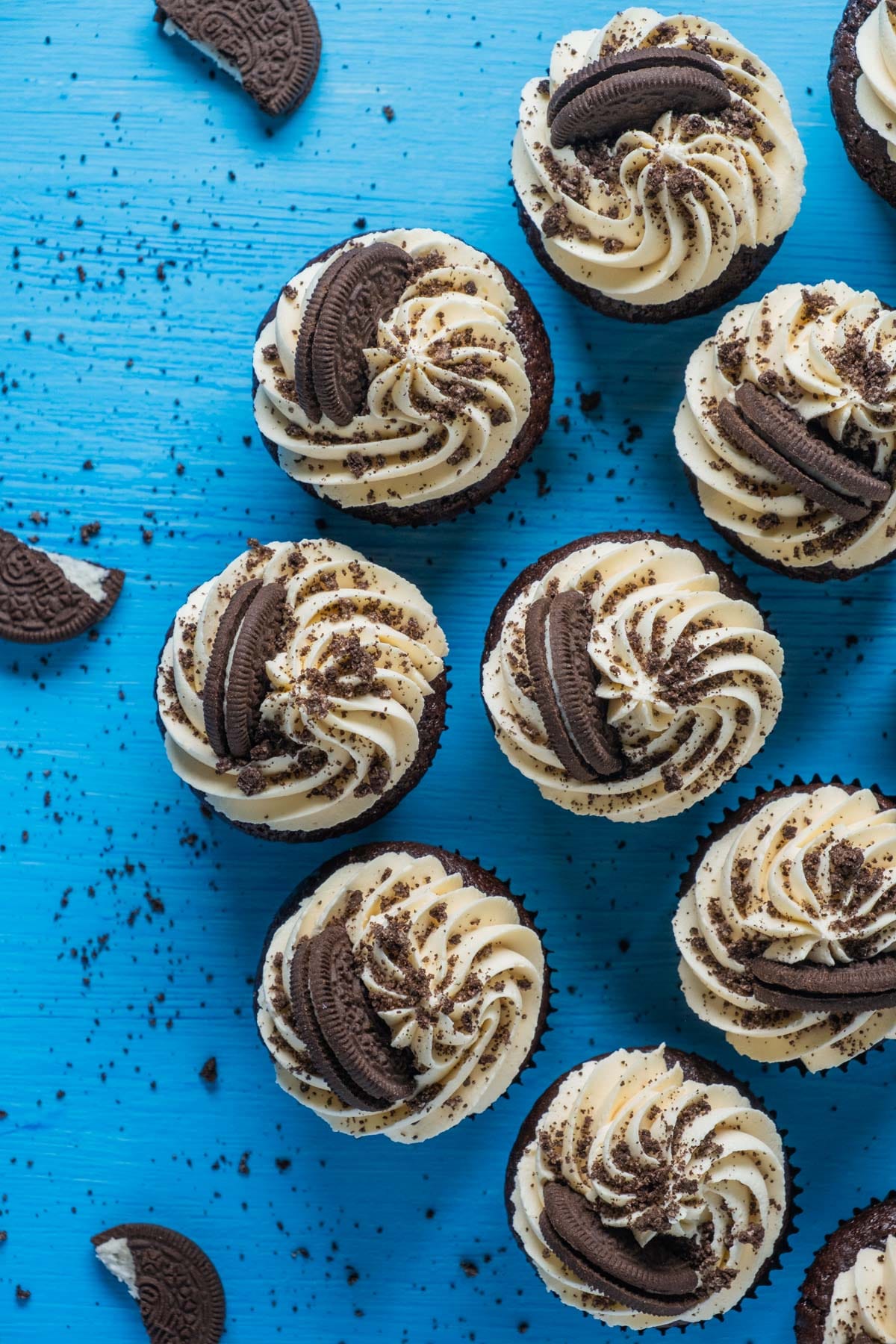 Vegan oreo cupcakes with frosting and oreo pieces on top.