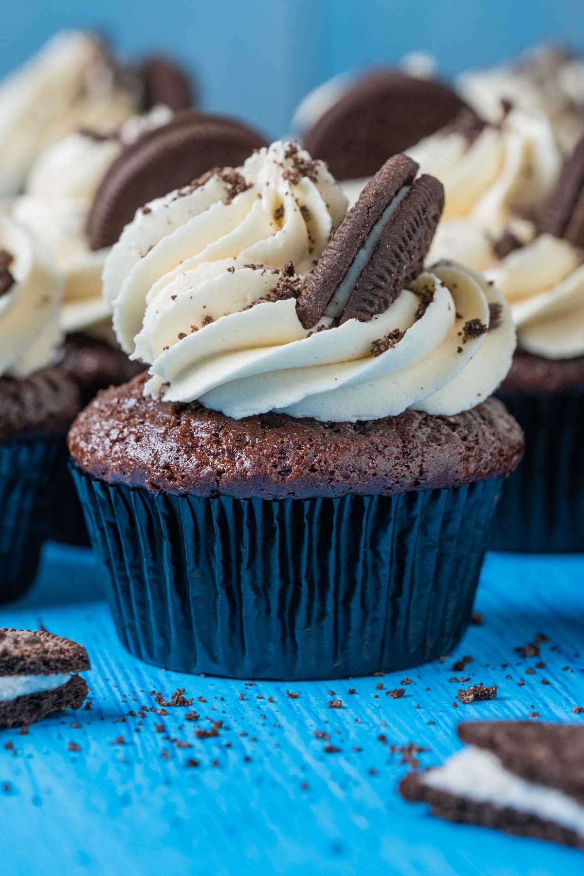 Vegan oreo cupcakes topped with vanilla frosting and oreo cookies.