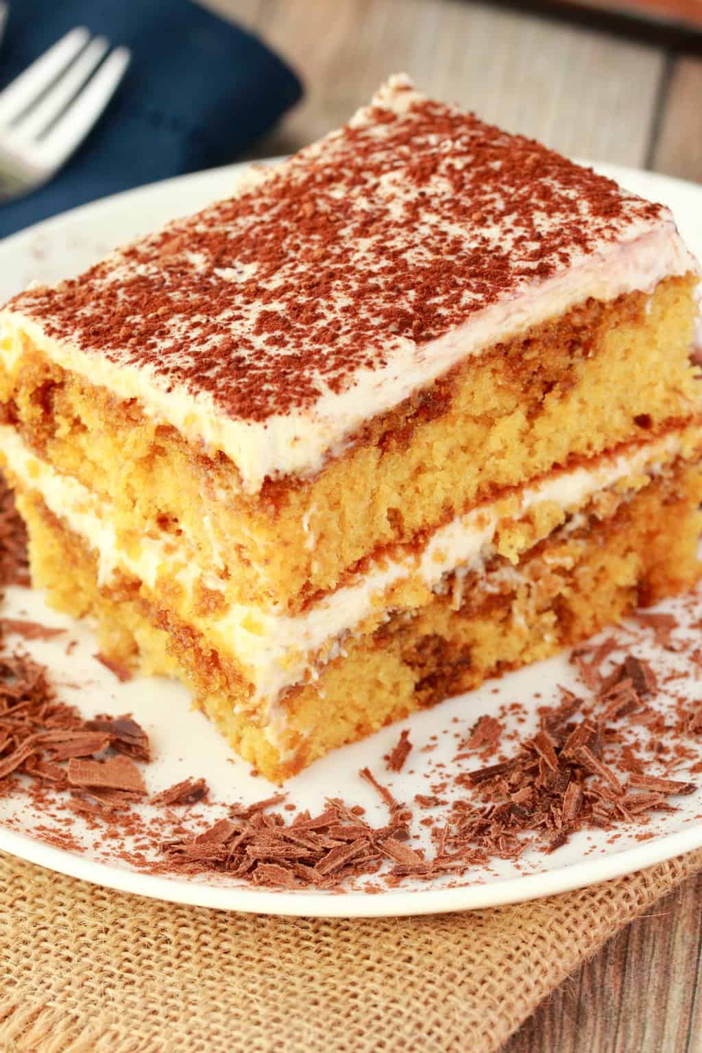 A slice of vegan tiramisu on a white plate with chocolate shavings. 